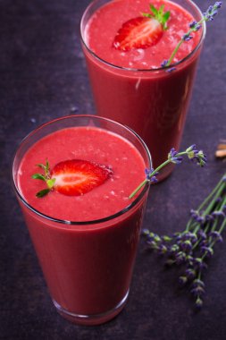 Berry smoothie çilek ve koyu ahşap arka plan lavanta çiçekleri ile süslenmiş