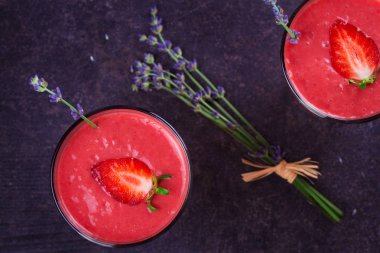 Berry smoothie çilek ve koyu ahşap arka plan lavanta çiçekleri ile süslenmiş