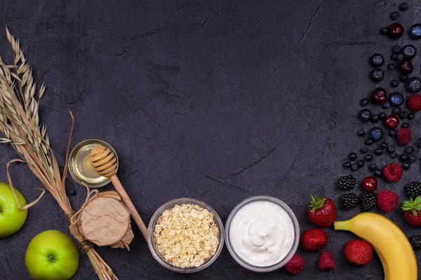 Kommen van yoghurt en Haver vlokken, verse appels, honing en zomer bessen. Weergave van bovenaf, top studio schot van vruchten. Plat lag setup gemaakt van gezonde voeding, kopie ruimte, horizontale samenstelling — Stockfoto