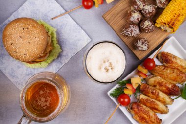 Bardak bira tavuk kanatları, hamburger, köfte, ızgara mısır ve sebze ile
