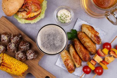 Bardak bira tavuk kanatları, hamburger, köfte, ızgara mısır ve sebze ile