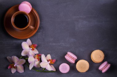 Kahve, orkide ve pasta macaron veya yukarıdan gri arka plan üzerinde acıbadem kurabiyesi
