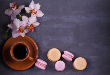 Kahve, orkide ve pasta macaron veya yukarıdan gri arka plan üzerinde acıbadem kurabiyesi