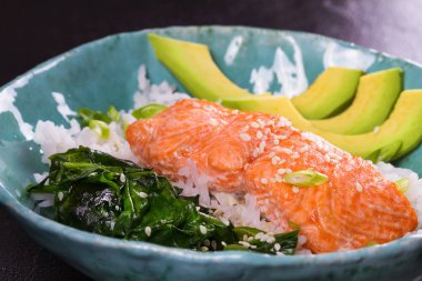 Ispanak ve avokado ile somon. Pirinç ve susam tohumu ile balık