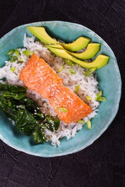 Ispanak ve avokado ile somon. Pirinç ve susam tohumu ile balık