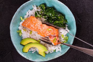 Ispanak ve avokado ile somon. Pirinç ve susam tohumu ile balık