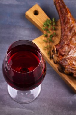 Bir bardak kırmızı şarap ve kaburga sığır eti. Şarap ve et natürmort