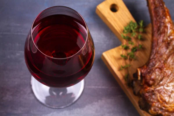 Un vaso de vino tinto y filete de ternera. Vino y carne bodegón —  Fotos de Stock