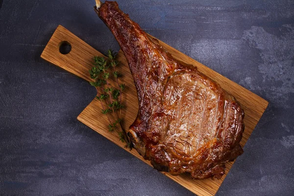 Filete de carne de costilla con tomillo en la tabla de cortar —  Fotos de Stock