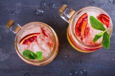 Kanlı turuncu kokteyl kavanozlara nane ile süslenmiş