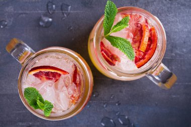 Kanlı turuncu kokteyl kavanozlara nane ile süslenmiş
