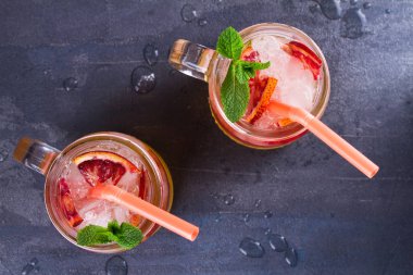 Kanlı turuncu kokteyl kavanozlara nane ile süslenmiş