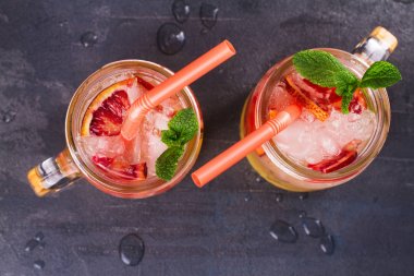 Kanlı turuncu kokteyl kavanozlara nane ile süslenmiş