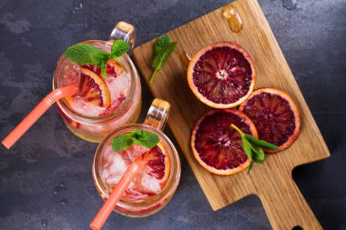 Kanlı turuncu kokteyl kavanozlara nane ile süslenmiş