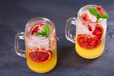 Kanlı turuncu kokteyl kavanozlara nane ile süslenmiş