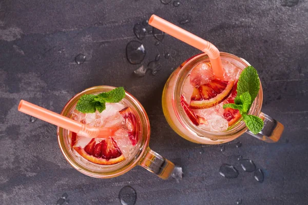 Kanlı turuncu kokteyl kavanozlara nane ile süslenmiş