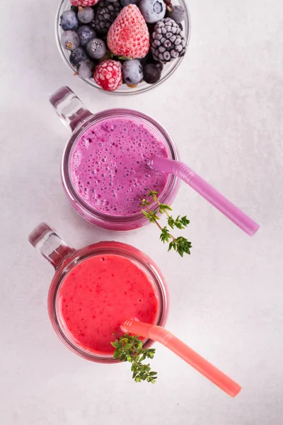 Batido de bayas de verano en los frascos sobre fondo rústico blanco — Foto de Stock