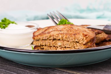 Ekşi krema ve maydanoz ile karaciğer köftesi. Karaciğer kek veya karaciğer börek. Sağlıklı atıştırma veya paket öğle yemeği ısırıkları