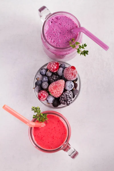 Batido de bayas de verano en los frascos sobre fondo rústico blanco — Foto de Stock