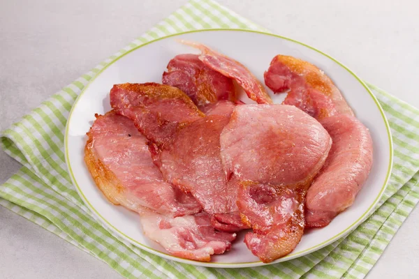 Bacon on white plate. Grilled rashers — Stock Photo, Image