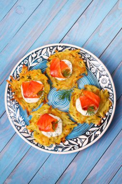 Somon ile patates gözlemesi. Sebze ile balık börek. Latkeler bir plaka üzerinde