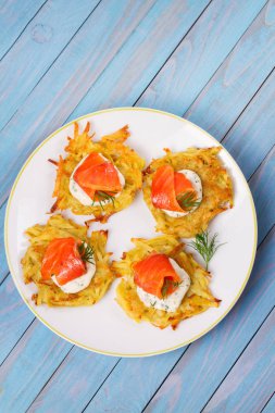 Somon ile patates gözlemesi. Sebze ile balık börek. Latkeler bir plaka üzerinde