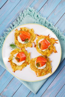 Somon ile patates gözlemesi. Sebze ile balık börek. Latkeler bir plaka üzerinde