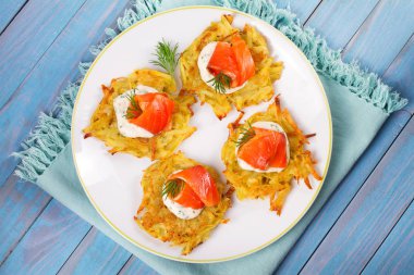 Somon ile patates gözlemesi. Sebze ile balık börek. Latkeler bir plaka üzerinde