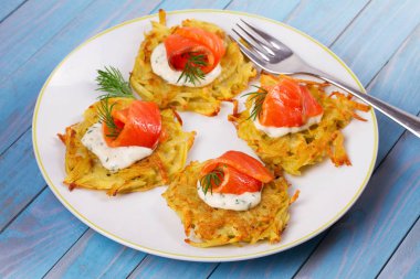 Somon ile patates gözlemesi. Sebze ile balık börek. Latkeler bir plaka üzerinde