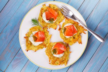 Somon ile patates gözlemesi. Sebze ile balık börek. Latkeler bir plaka üzerinde
