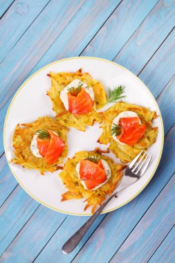 Somon ile patates gözlemesi. Sebze ile balık börek. Latkeler bir plaka üzerinde