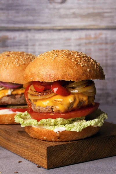 Biffburgere med rød og gul paprika, napakål, tomat og cheddar – stockfoto