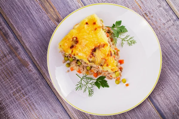 Carne, patata, queso, zanahoria, cebolla y guisantes verdes. Pastel de pastor tradicional — Foto de Stock