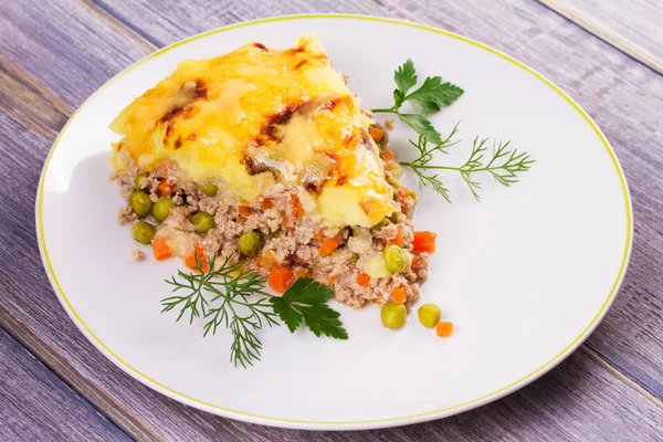 Meat, potato, cheese, carrot, onion and green peas casserole. Traditional shepherd pie