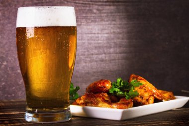 Bir bardak bira ve buffalo tavuk kanatları. Bira ısırıkları