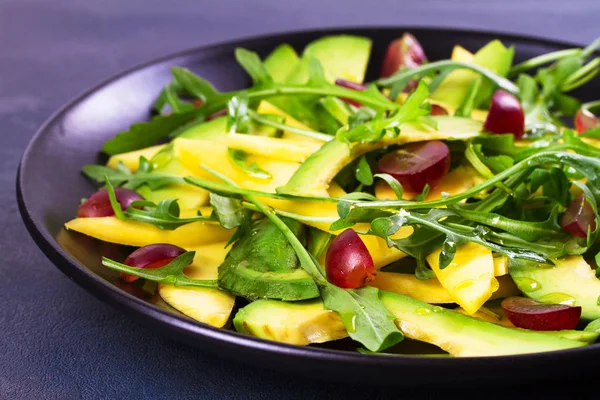 Avokádó, mangó, piros szőlő, és a fekete nyomólapra sült saláta kitûnõ saláta — Stock Fotó