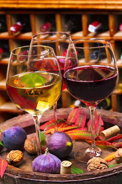 Bicchieri di vino rosso, rosato e bianco con uva in cantina. Concetto di cibo e bevande — Foto Stock