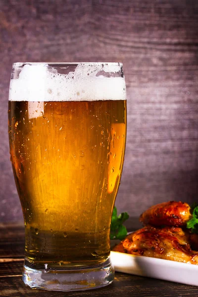 Bir bardak bira ve buffalo tavuk kanatları. Bira ısırıkları