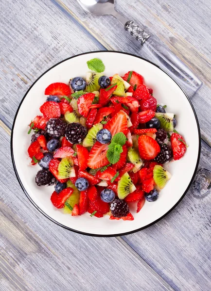 Ensalada de fresa, mora, arándanos y kiwi, decorada con menta —  Fotos de Stock