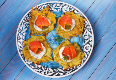 Patates Pancakes füme somon ile. Sebze ile balık börek. Latkeler bir plaka üzerinde