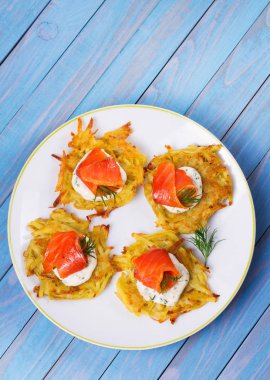 Patates Pancakes füme somon ile. Sebze ile balık börek. Latkeler bir plaka üzerinde