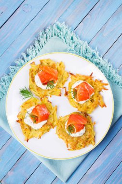 Patates Pancakes füme somon ile. Sebze ile balık börek. Latkeler bir plaka üzerinde