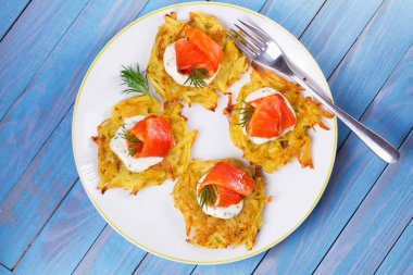 Patates Pancakes füme somon ile. Sebze ile balık börek. Latkeler bir plaka üzerinde