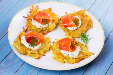 Patates Pancakes füme somon ile. Sebze ile balık börek. Latkeler bir plaka üzerinde