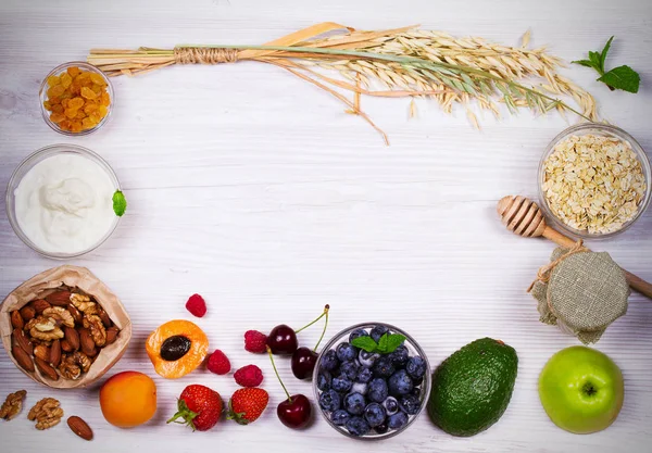 Kommen van yoghurt en Haver vlokken, fruit, honing en zomer bessen. Weergave van bovenaf, top studio shot van groenten achtergrond — Stockfoto