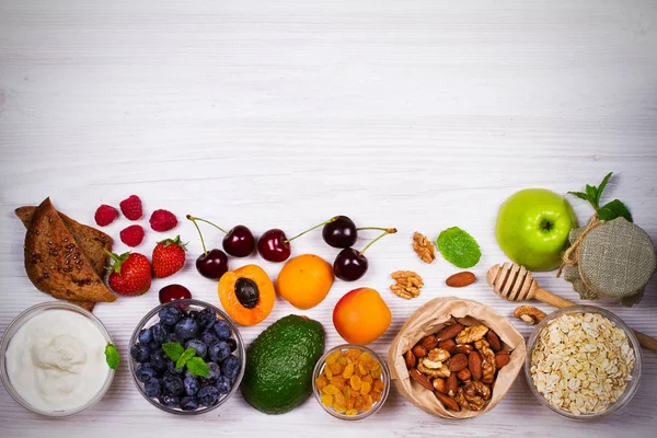 Kommen van yoghurt en Haver vlokken, fruit, honing en zomer bessen. Weergave van bovenaf, top studio shot van groenten achtergrond — Stockfoto