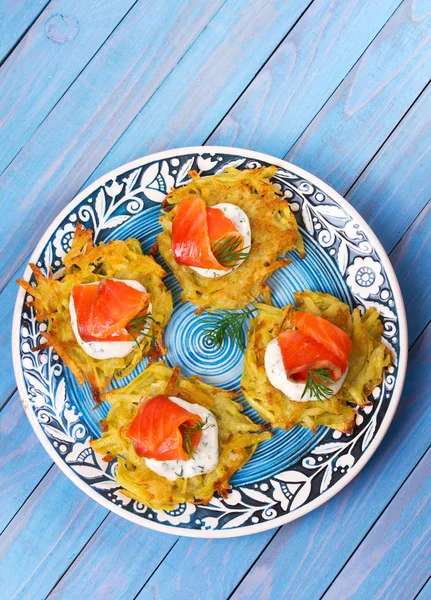 Patates Pancakes füme somon ile. Sebze ile balık börek. Latkeler bir plaka üzerinde