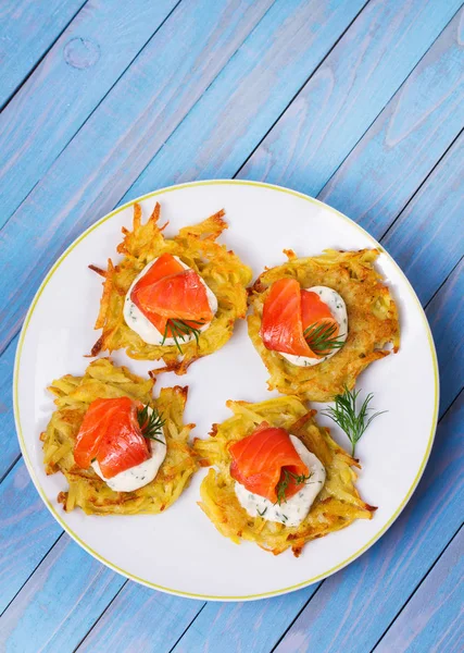 Patates Pancakes füme somon ile. Sebze ile balık börek. Latkeler bir plaka üzerinde