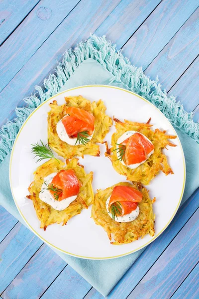 Patates Pancakes füme somon ile. Sebze ile balık börek. Latkeler bir plaka üzerinde