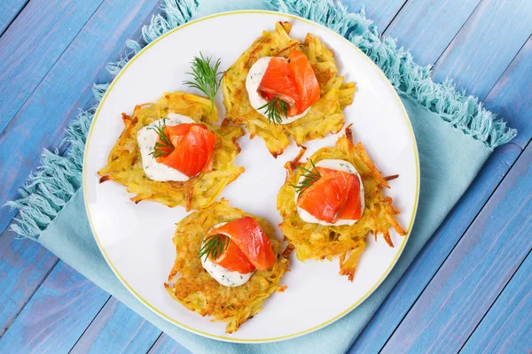 Patates Pancakes füme somon ile. Sebze ile balık börek. Latkeler bir plaka üzerinde